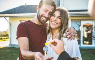 smiling couple receiving key to their home